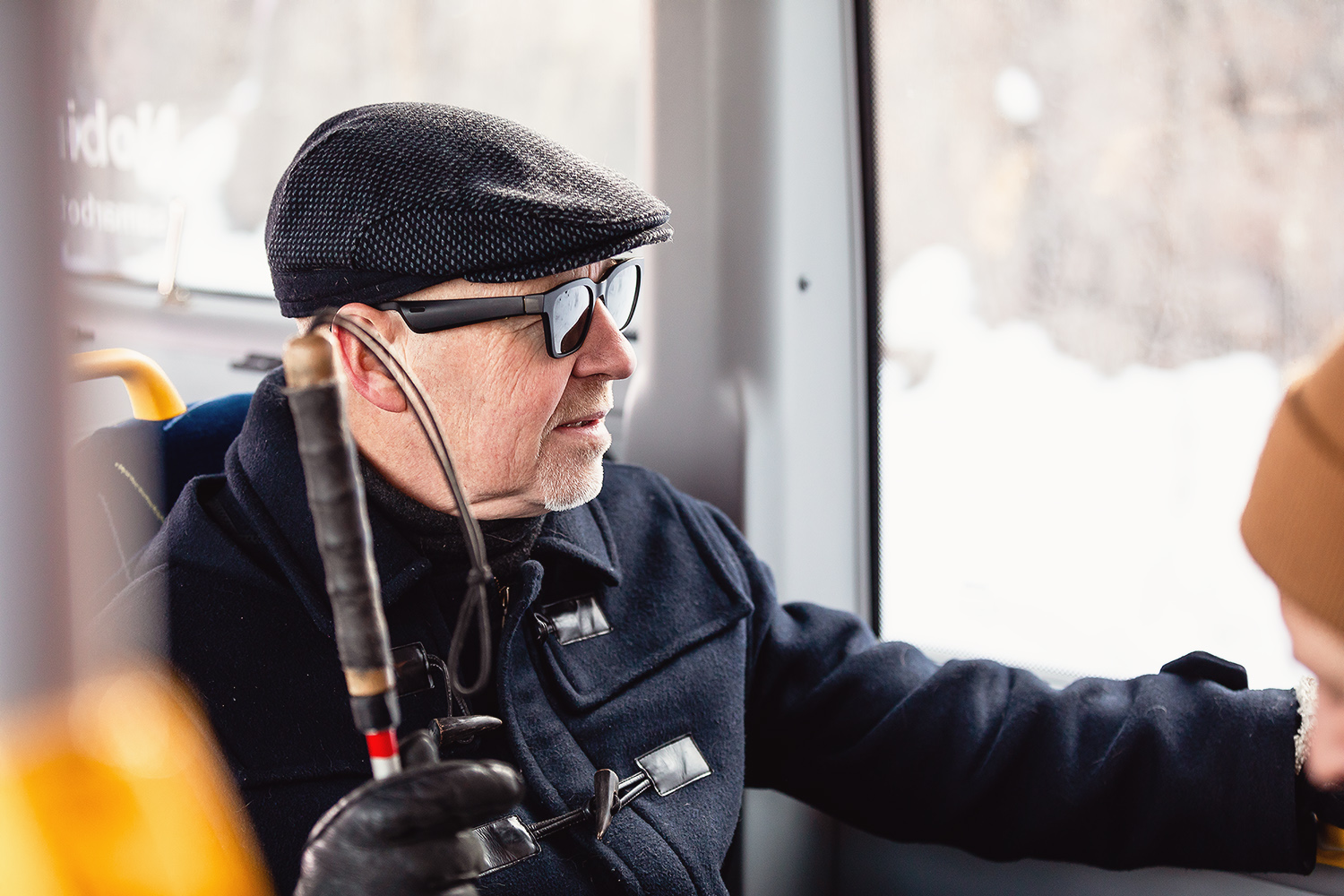 Passenger on bus with white cane and glasses