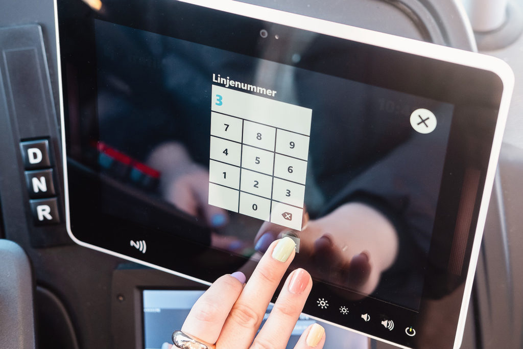 Driver manually changing the route on a journey by pressing digital buttons on a screen.